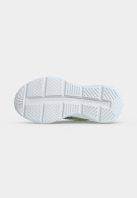 Semelle extérieure en caoutchouc blanc d'une basket avec motifs de bande de roulement texturés et rainures pour l'adhérence et la flexibilité sur un fond uni.