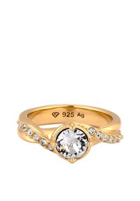 Guldtonad ring med en central rund klar ädelsten, omgiven av mindre infattade stenar längs en tvinnad ring. Märkt "925 Ag."