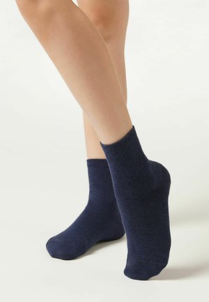 Marinblå ankelsockor i mjukt, strukturerat tyg med ribbad mudd, som har en passande form som anpassar sig efter foten.