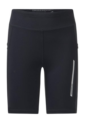 Adolescent en t-shirt de sport gris et short noir tenant une bouteille d'eau bleue, debout avec une expression neutre sur fond blanc.