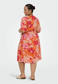 Floral dress featuring large orange and pink flowers on a light background, short sleeves, waist tie, and a knee-length hem.