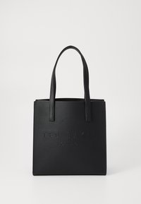 Sac fourre-tout noir en matériau synthétique texturé, logo en relief sur le devant, et deux solides poignées plates. Forme carrée avec un haut ouvert.