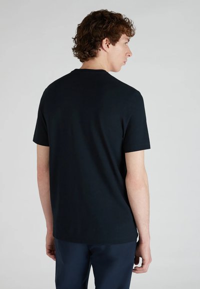 Camiseta negra de manga corta hecha de algodón, con un cuello redondo, textura suave y un diseño simple sin gráficos ni patrones.