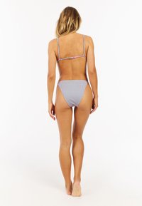 Blauwe en roze gestreepte bikini met dunne bandjes en een laag uitgesneden broekje, met verstelbare bevestigingsmiddelen op de rug. Glad stoffen textuur.