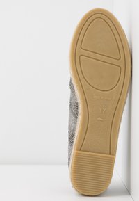 Semelle de chaussure en caoutchouc marron clair avec grip texturé, marquée "Made in Spain" et taille 37, sur fond blanc.