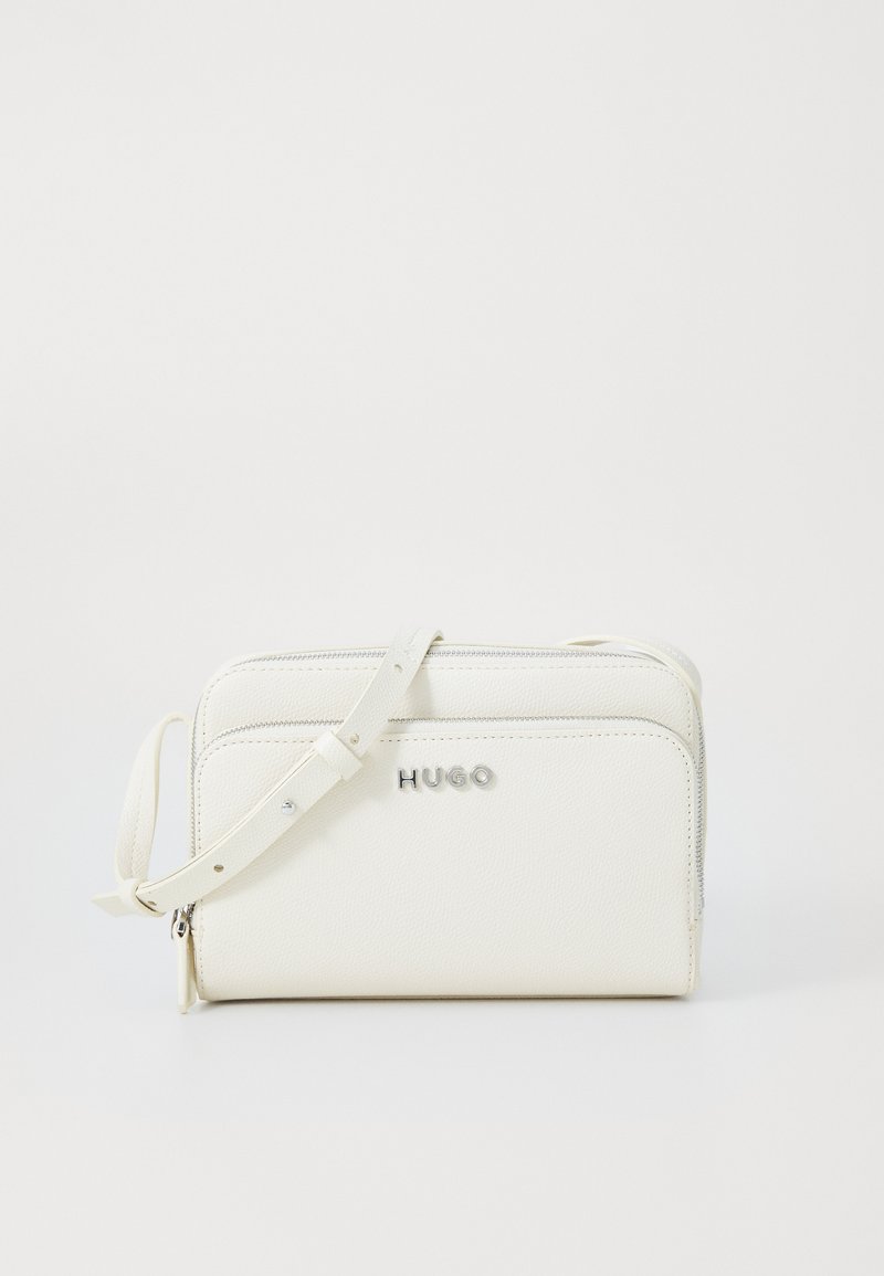 Witte leren crossbody tas met een ritsluiting, zilverkleurig logo en verstelbare schouderriem. Gestructureerd oppervlak en minimalistisch ontwerp.