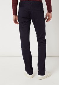 Chinos azul marino con corte slim. Cuenta con una cintura con trabillas, dos bolsillos traseros y detalles de costura sutiles. Tejido de algodón suave.