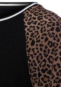 Zwarte t-shirt met een panterprintpaneel in bruine tinten, met contrasterende witte en zwarte afwerking langs de halslijn.