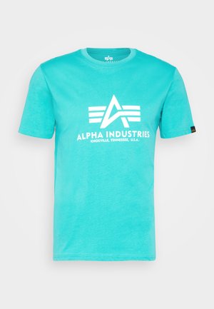 Tirkizna pamučna majica s bijelim logom s tri horizontalne pruge i natpisom "ALPHA INDUSTRIES, KNOXVILLE, TENNESSEE, U.S.A."