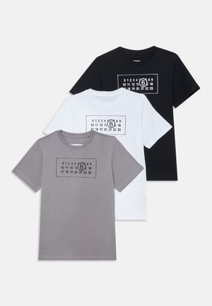 Tre T-shirt: nera, bianca e grigia. Ognuna ha una grafica rettangolare con numeri e la cifra "6" stampata in nero sulla parte anteriore.