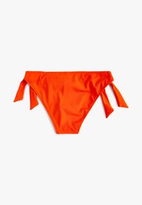 Jasnopomarańczowy dół bikini z bocznymi zapięciami, wykonany z elastycznego materiału. Posiada gładką teksturę i zaprojektowany jest w klasycznym kształcie fig.