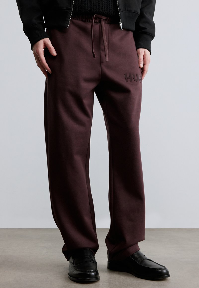 Pantaloni de trening bordo, cu croială lejeră, având talie elastică, șnur ajustabil și logo în relief pe coapsa stângă.