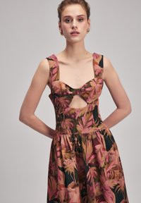Blumenkleid mit taillierter Oberteile und Ausschnitt, breiten Trägern und einem ausgestellten Rock. Die Farben umfassen Pink, Grün und Braun mit einem strukturierten Stoff.