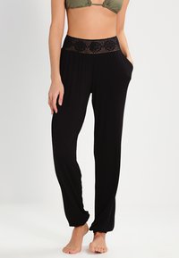 Pantalones de corte ancho negros con una cinturilla de crochet negro texturizada, que cuentan con bolsillos laterales y una tela suave y ligera.