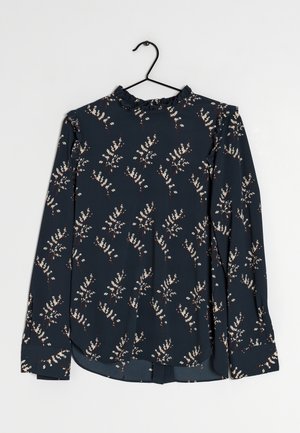 Marineblauwe blouse met lange mouwen, wit bloemmotief, gerimpelde kraag en licht gebogen zoom, getoond op een zwarte hanger.