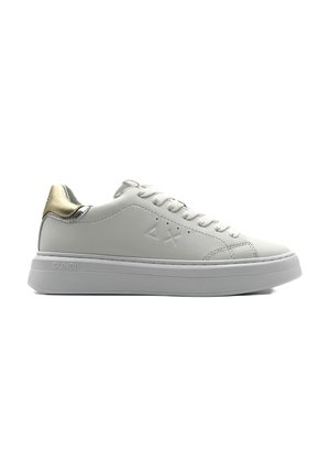 Sneaker bianco in pelle con suola spessa bianca. Presenta un accento metallico dorato nel tallone e un dettaglio del logo sul lato. Include i lacci.