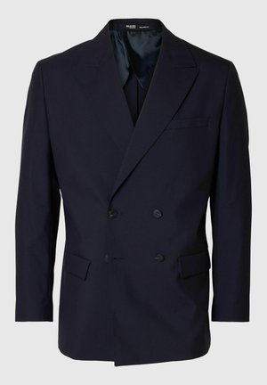 Blazer de doble botonadura en azul marino, confeccionado en un tejido suave, con cuello de chal, dos bolsillos delanteros y botones negros en la parte delantera.