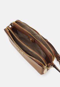 Portafoglio in pelle marrone con cerniere dorate. Presenta due scomparti foderati in tessuto chiaro, chiusura a pulsante e un design sottile.