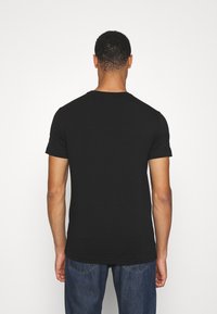 Svart T-shirt med kort ärm i bomull, med rund halsringning och en enkel, odekorerad design med en mjuk textur.