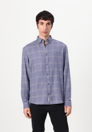Purple plaid long-sleeve shirt with a button-down collar, featuring a subtle check pattern and a curved hem. Buttons down the front.