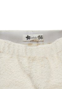 White fleece garment with a soft, textured surface. Features a tag with the brand "Sterntaler" and size "56" stitched inside a waistband.