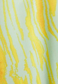 Tissu vert clair avec des rayures jaunes ondulées, créant un motif abstrait texturé avec des largeurs et une intensité variables.