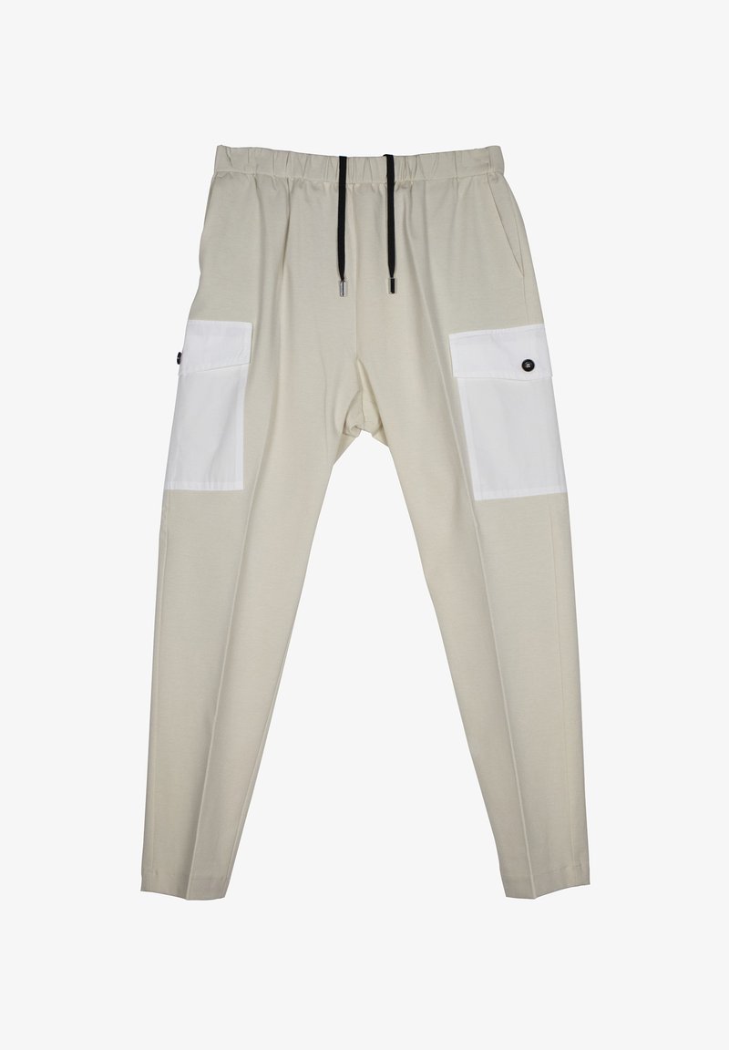 Beige elastische broek met een losse fit, voorzien van witte patchzakken aan de zijkanten, zwarte trekkoorden en knoopaccenten op de zakken.