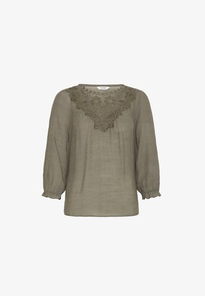 Alyvinė žalia, laisvai krentanti palaidinė su subtilia gėlių nėrinių apykakle. Ilgos rankovės su susikaupusiomis rankogaliais ir švelni tekstūra.