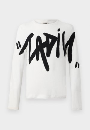 Witte blouse met lange mouwen met grote zwarte tekst die "LADIES" zegt. Zachte stof met een ronde halslijn en een normale pasvorm.