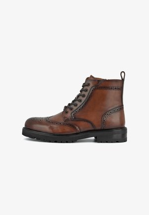 Brown leather ankle boot with brogue detailing, rounded toe, black rubber sole, and side pull tab. Features traditional lacing.