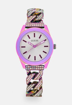 Guess wristwatch with iridescent pink case, silver dial, purple hour markers, and a chain-link band adorned with rhinestones.