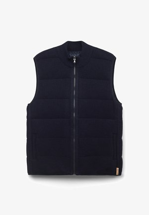 Marinblå stickad väst med hög krage, vadderad design, dragkedja fram och sidofickor. Har texturerad tyg och kontrasterande detaljer.