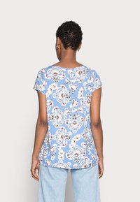 Helles blaues Kurzarm-Oberteil mit einem floralen Muster in Weiß, Rot und Schwarz. Weicher Stoff mit lässiger Passform und abgerundetem Saum.