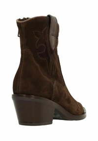 Stivaletto in suede marrone con cerniera laterale, cuciture distintive e tacco curvo. Presenta dettagli floreali nella parte superiore.