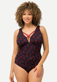 Maillot de bain une pièce marine avec motif floral rouge, décolleté en V et bretelles croisées. Matériau doux et design ajusté sur mesure.