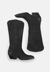 Botas de cowboy de cuero negro con un diseño texturizado y punta afilada. Presentan un tacón apilado y costuras decorativas en el caña.