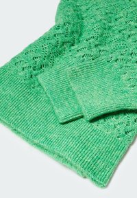 Groene gebreide trui met een textuurpatroon, geribbelde manchetten en een zachte, lichte stof. Accenturen van heidel groen zichtbaar.