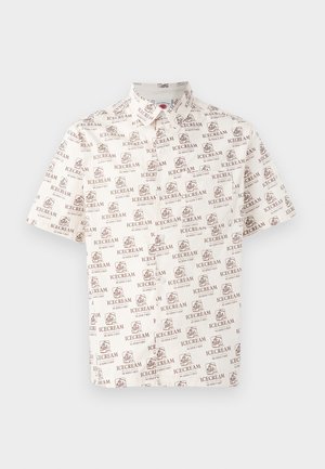 Kremkrāsas īsām piedurknēm krekls ar brūnu atkārtotu saldējuma drukāšanu. Apkakles dizains ar pogu aizdari pie kakla.