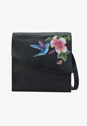 Zwarte leren tas met een bloemmotief, inclusief een kolibrie en een hibiscus. Gladde textuur, omslagflap en een schouderriem.