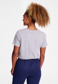 Gr�å bomulds t-shirt med korte ærmer, rund hals og en afslappet pasform, kombineret med navyblå bukser med elastik i taljen. Tekstureret stof synligt.