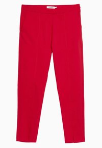 Pantalons ajustés rouges avec une texture lisse, une taille plate, deux poches latérales et des coutures avant menant à des fentes au niveau de l' ourlet.