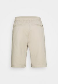 Beige bavlněné šortky s elastickým pasem, dvěma zadními kapsami a rovný střih nohavic. Hladká textura s minimalistickým designem.