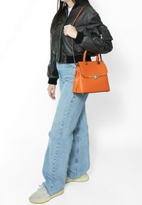 Oranje leren handtas met een gestructureerde vorm, bovenhandgrepen en een afneembare schouderband. Voorzien van gouden hardware en een gevouwen klepsluiting.