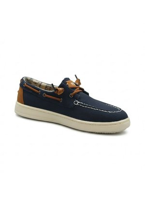 Scarpa da barca blu navy con cuciture bianche, lacci in pelle marrone, rinforzo sul tallone e suola in gomma bianca su sfondo bianco.