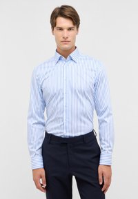 Blauw-wit gestreepte overhemden met lange mouwen, knoopsluiting aan de voorkant en contrasterende gestreepte manchetten. Gladde stof en op maat gemaakte pasvorm.