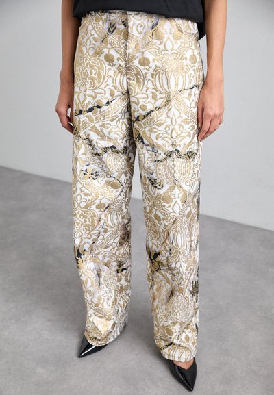 Pantaloni largi, de culoare albă, cu un model floral auriu și accente negre. Prezintă o textură netedă și buzunare laterale. Asortați cu tocuri negre.