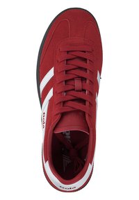 Baskets de sport en suède rouge avec des accents blancs et trois rayures blanches, dotées d'un système de laçage et d'une semelle en caoutchouc noir.