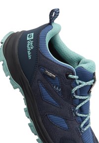 Scarpa da trail con tomaia in tessuto blu scuro e accenti blu chiaro, sovrapposizioni testurizzate, colletto imbottito e suola in gomma robusta.