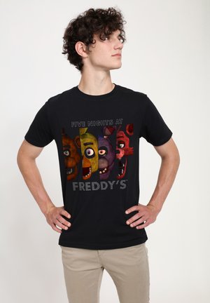 Camiseta negra de algodón con personajes de dibujos animados coloridos, con ojos grandes y sonrisas, texto que dice "FIVE NIGHTS AT FREDDY'S" debajo.