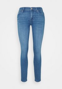 Jeans skinny de denim azul con una cintura estándar, bolsillos frontales y una textura suave. Presentan un cierre de botón metálico y presillas para el cinturón.